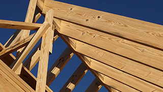 Image of Ƶ wood products used to frame a house on a job site.