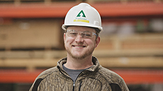 Image of a warehouse employee wearing a white Ƶ-branded hardhat.